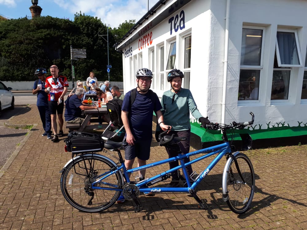 Meredith and Graham with their tandem, stopped outside a cafe in Dunoon